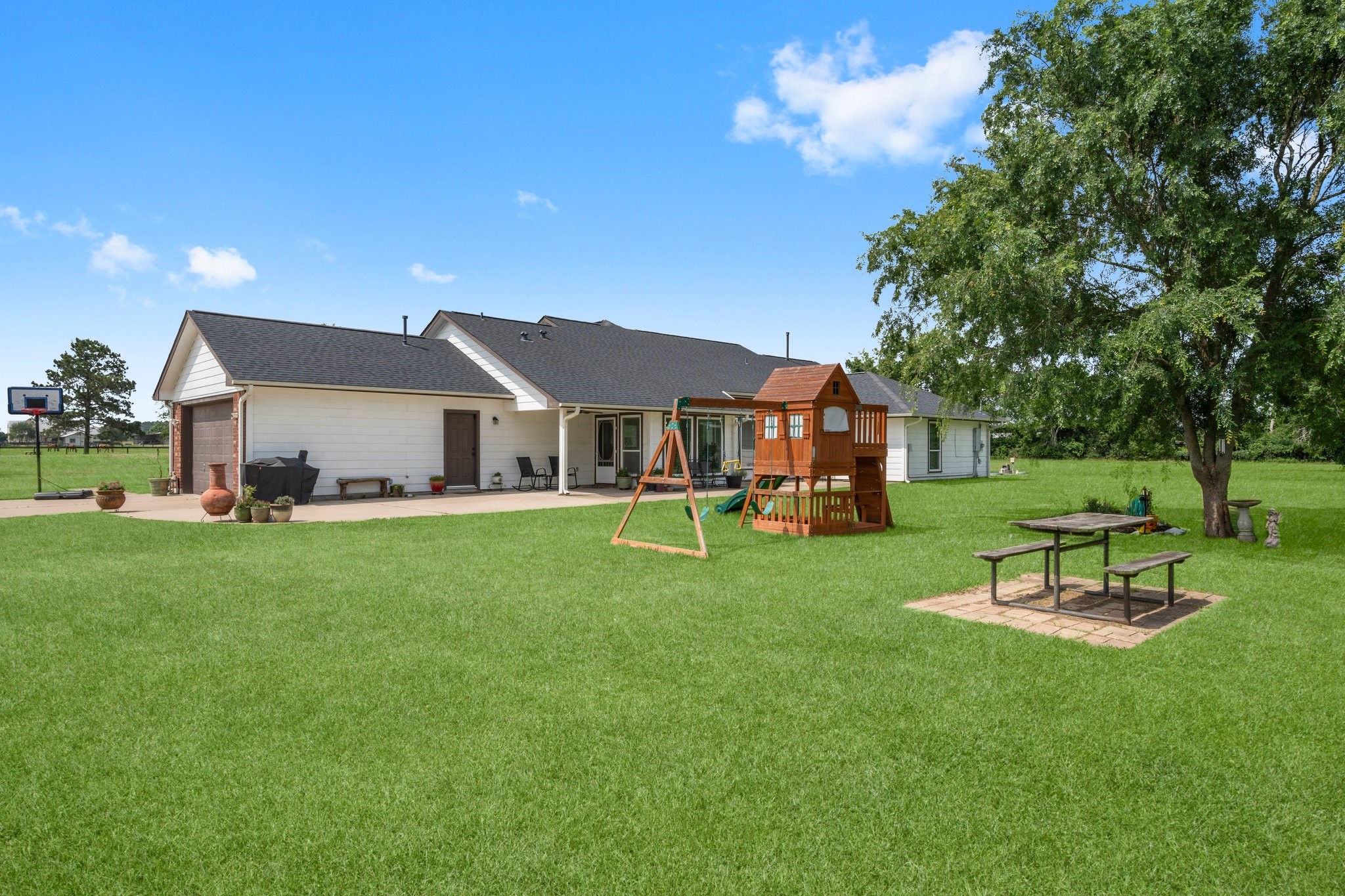34334 Howell Road Waller, TX 77484 - Photo 26 of 37 Perfect for families, this property boasts a huge backyard complete with a playset and a picnic table, creating a wonderful environment for outdoor fun and making memories.
