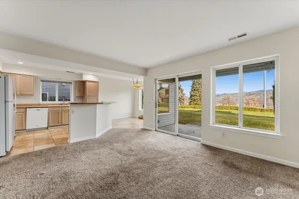an empty room with a kitchen and windows
