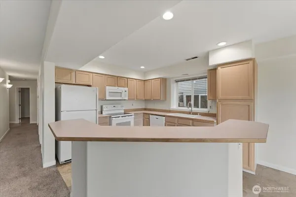 a kitchen with stainless steel appliances granite countertop a sink and refrigerator