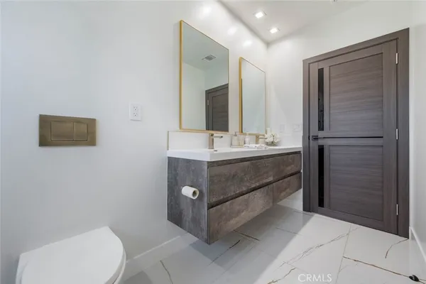 a bathroom with a sink vanity mirror and toilet