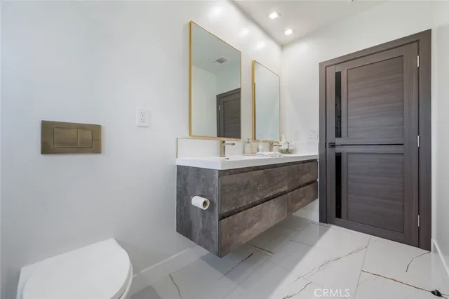 a bathroom with a sink vanity mirror and toilet