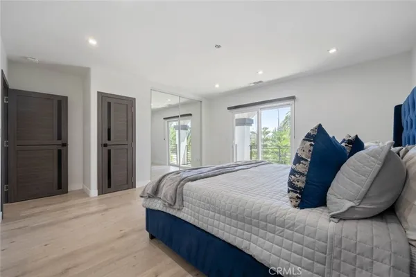 a bedroom with a bed and a large window