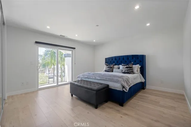 a bed sitting in a spacious bedroom next to a window