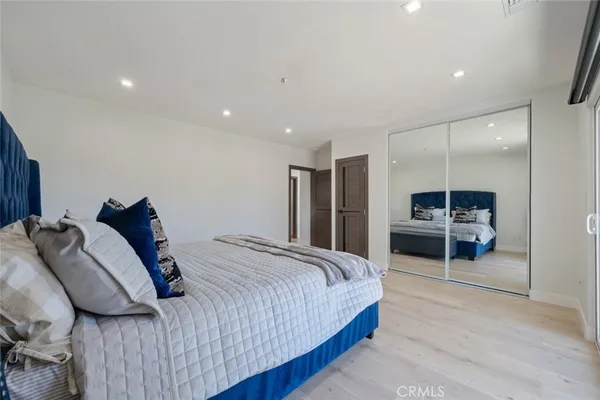 a spacious bedroom with a bed and a mirror