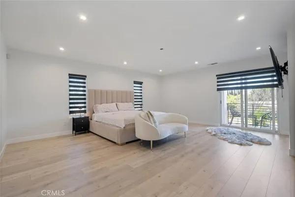 a spacious bedroom with a bed and a large window