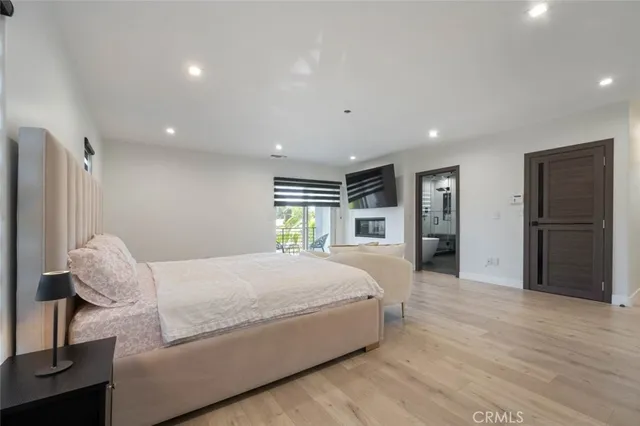 a spacious bedroom with a large bed and wooden floor