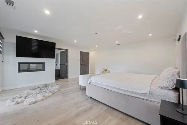 a living room with a bed and a flat screen tv