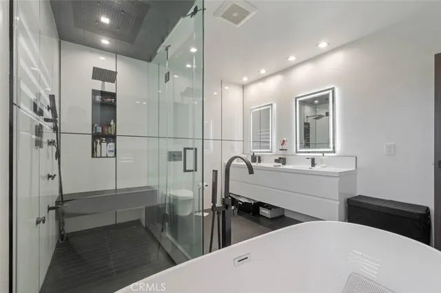 a bathroom with double vanity and a bathtub