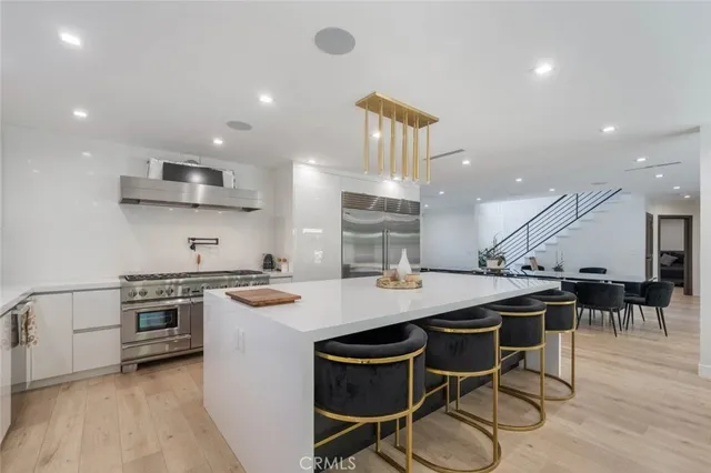 a kitchen with a stove a table and chairs in it