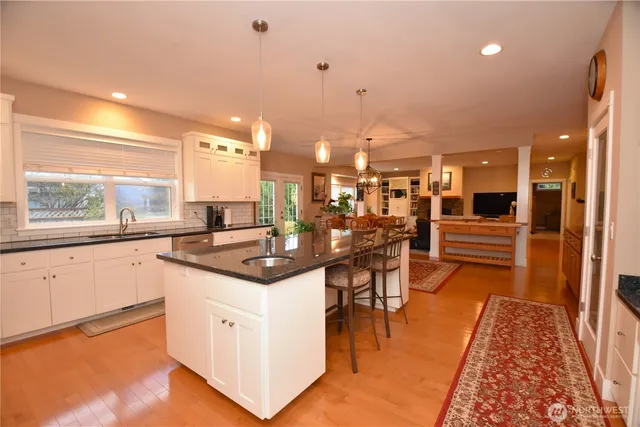 a kitchen with stainless steel appliances kitchen island granite countertop a stove a sink and a refrigerator