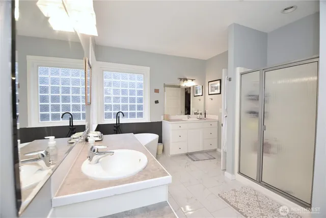 a spacious bathroom with a sink double vanity and a shower