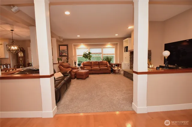 a living room with furniture a flat screen tv and a large window