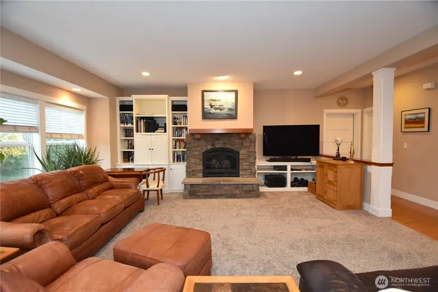 a living room with furniture a flat screen tv and a fireplace