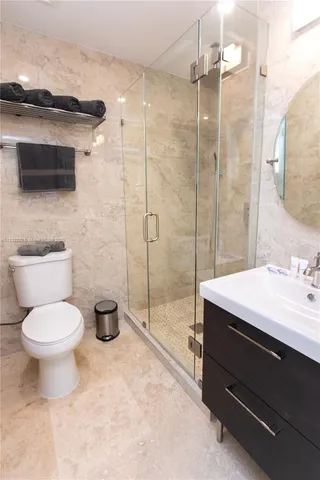 a bathroom with a sink toilet vanity and shower