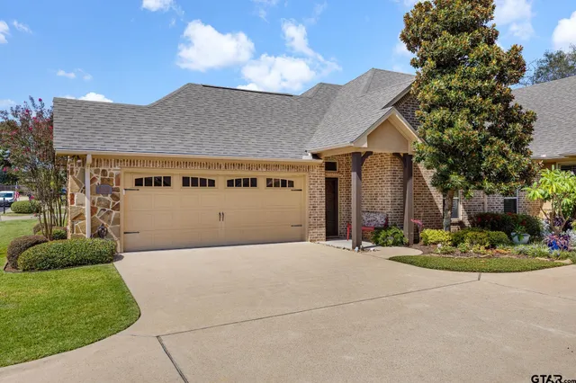 a front view of a house with a garden and garage