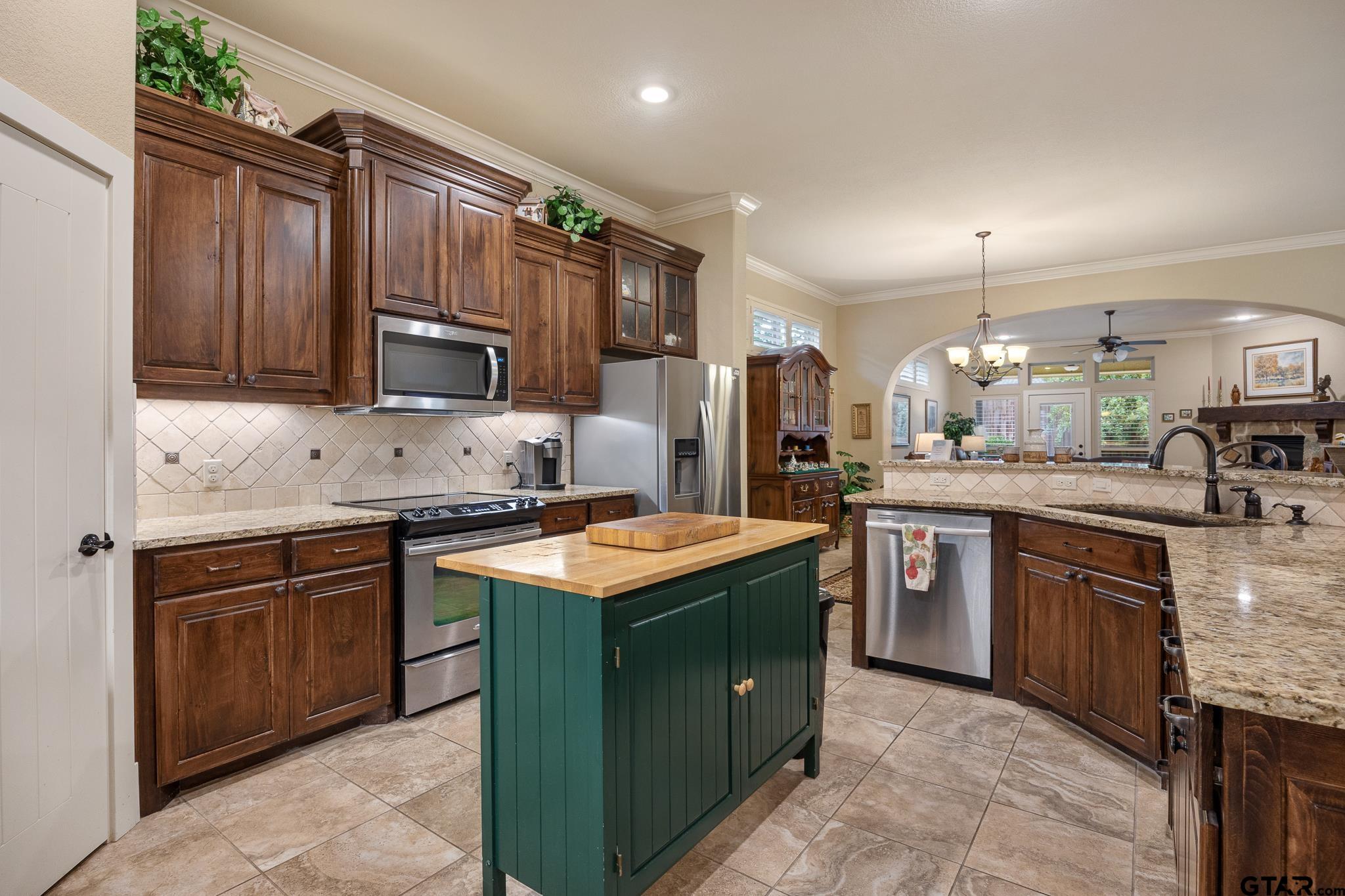 4322 Madera Drive Tyler, TX 75707 - Photo 6 of 32 a kitchen with kitchen island granite countertop a sink stove and refrigerator