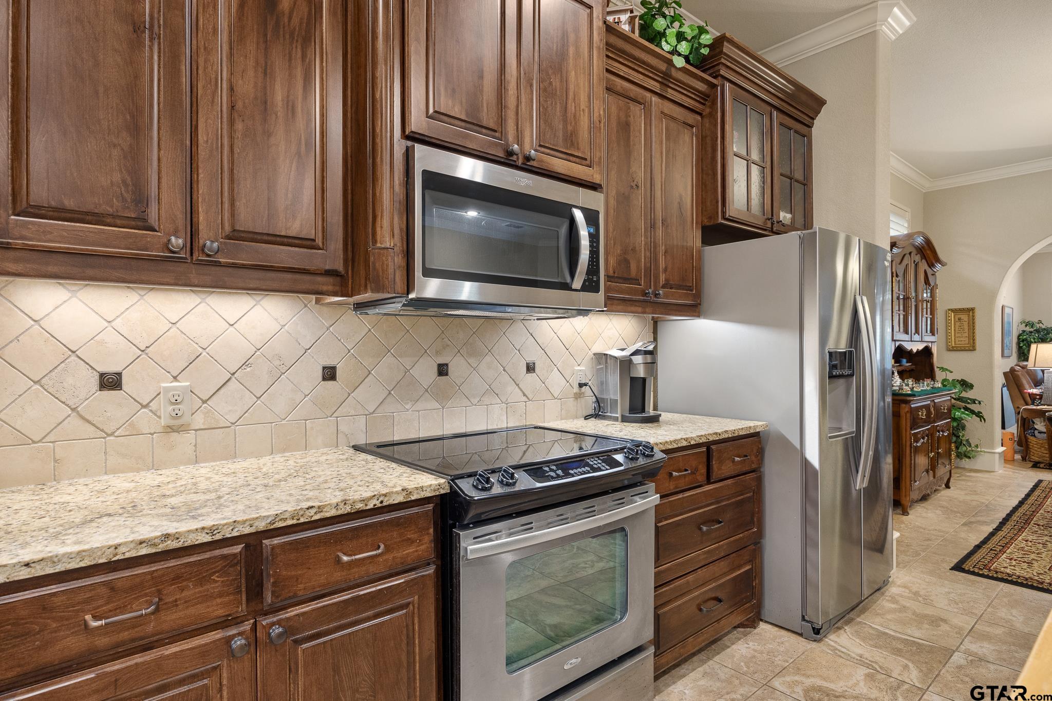 4322 Madera Drive Tyler, TX 75707 - Photo 8 of 32 a kitchen with granite countertop cabinets stainless steel appliances and wooden cabinets