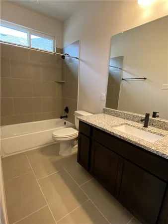 a bathroom with a granite countertop sink a toilet and bathtub