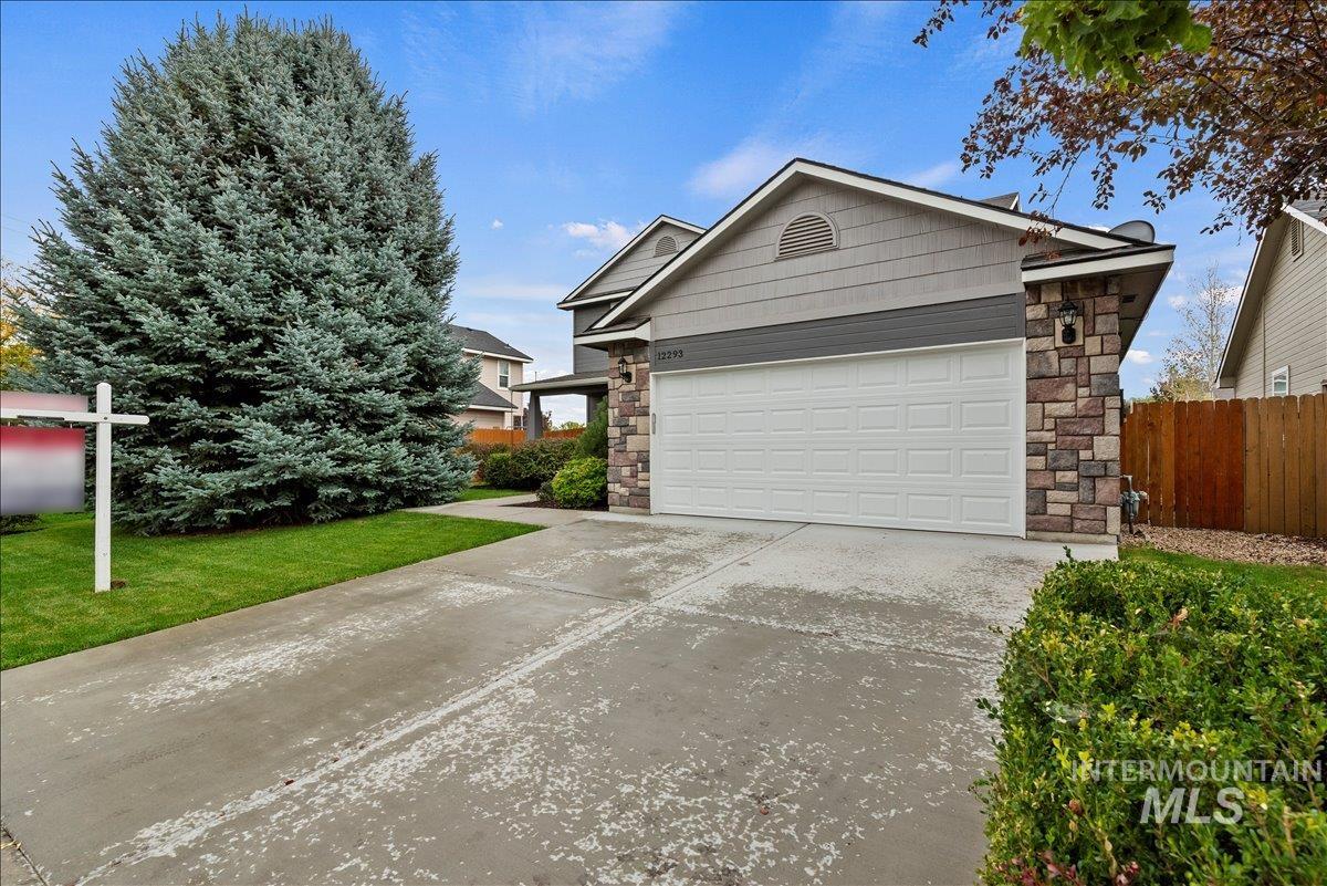 12293 West Murchison Street Boise, ID 83709 - Photo 24 of 27 View of front of property with stone siding, driveway, and an attached garage