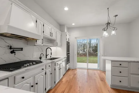 a kitchen with stainless steel appliances granite countertop a sink stove and cabinets