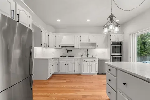 a kitchen with stainless steel appliances a refrigerator sink and cabinets