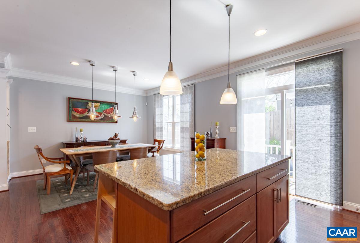 2140 Avinity Loop Charlottesville, VA 22902 - Photo 11 of 26 a kitchen with stainless steel appliances granite countertop a sink a oven a dining table and chairs with wooden floor