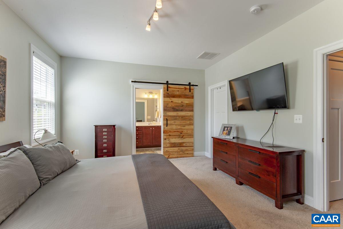 2140 Avinity Loop Charlottesville, VA 22902 - Photo 17 of 26 a bedroom with a bed and a flat screen tv