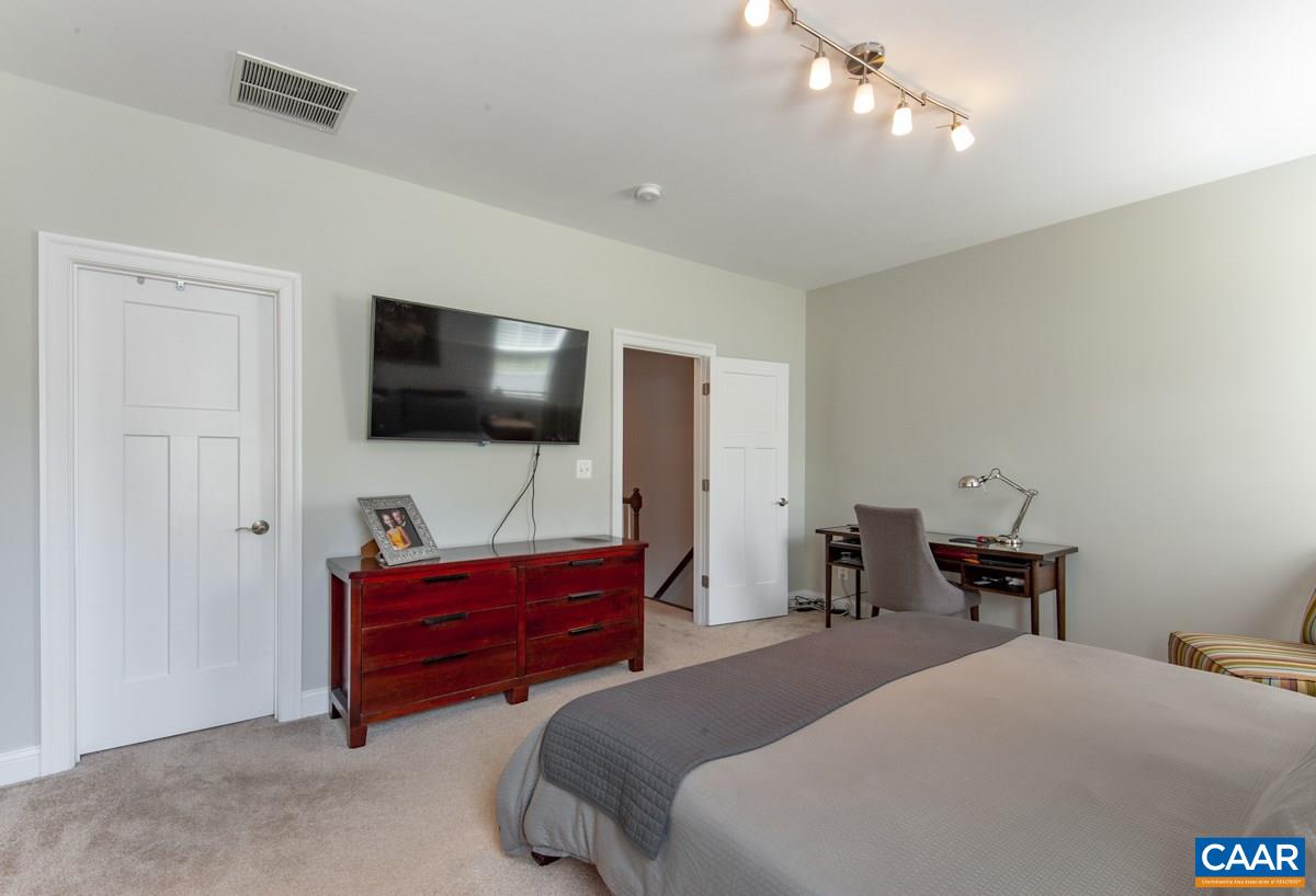 2140 Avinity Loop Charlottesville, VA 22902 - Photo 18 of 26 a bedroom with a bed and a flat tv screen on a dresser