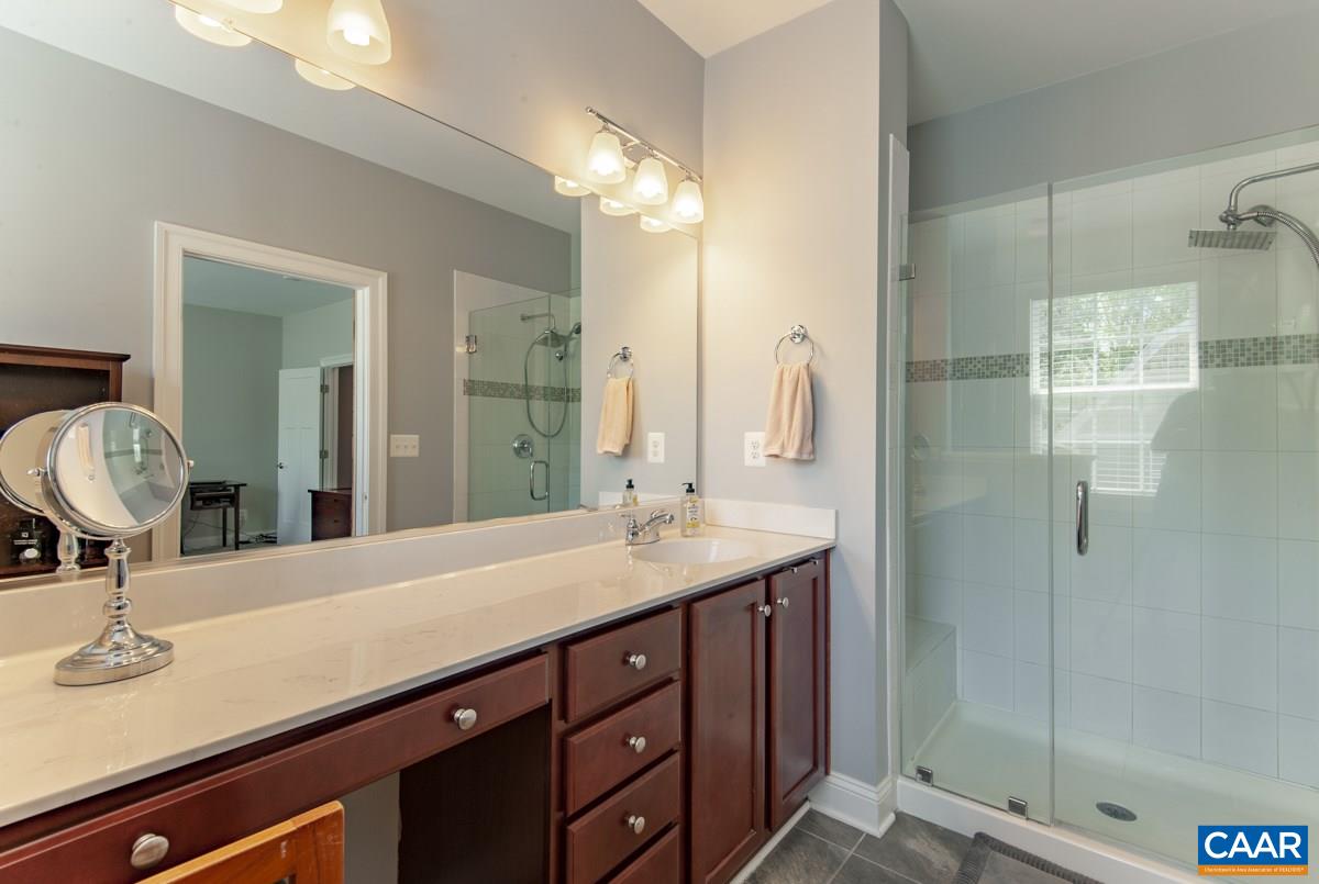 2140 Avinity Loop Charlottesville, VA 22902 - Photo 19 of 26 a bathroom with a granite countertop sink a mirror and a shower
