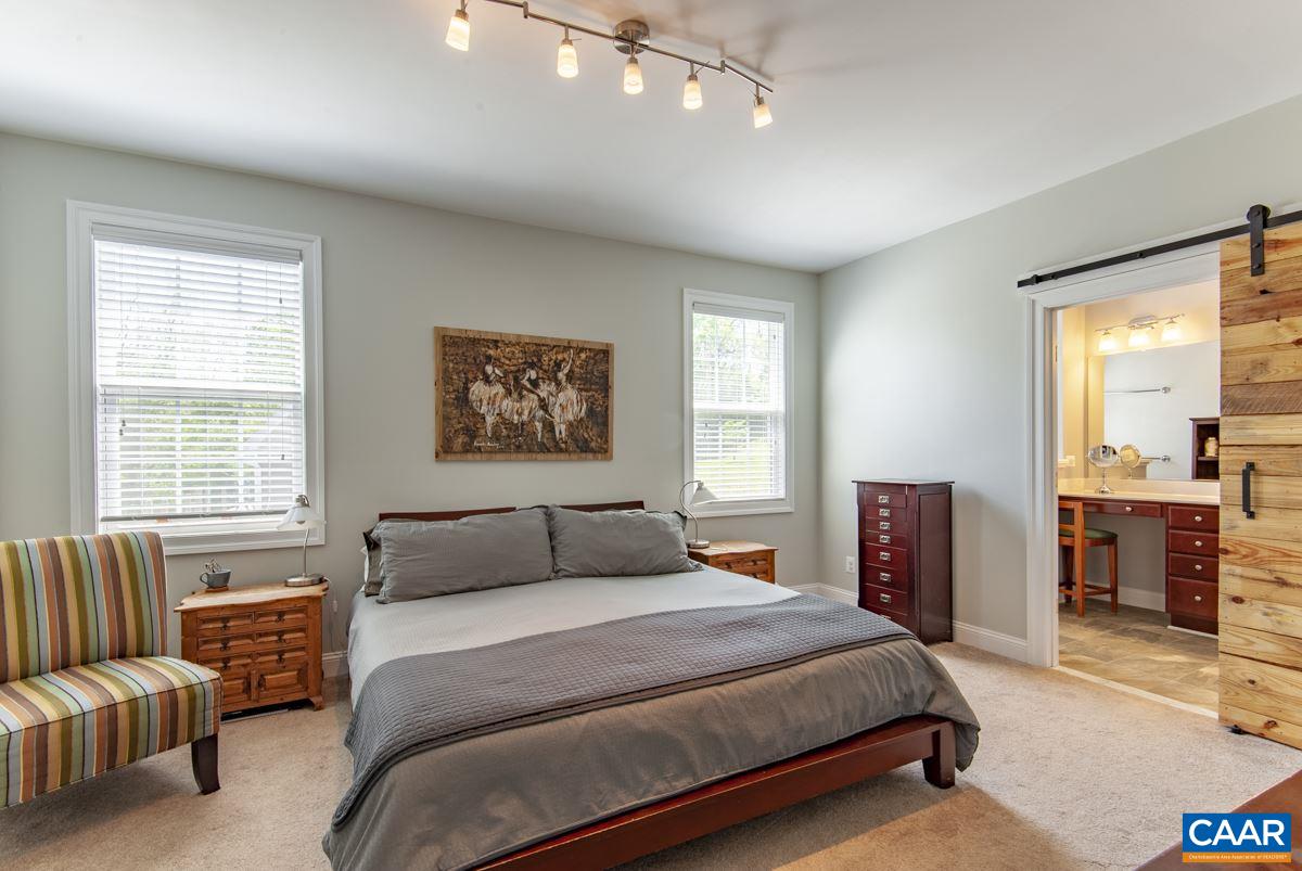 2140 Avinity Loop Charlottesville, VA 22902 - Photo 4 of 26 a bedroom with a balcony a bed and a couch