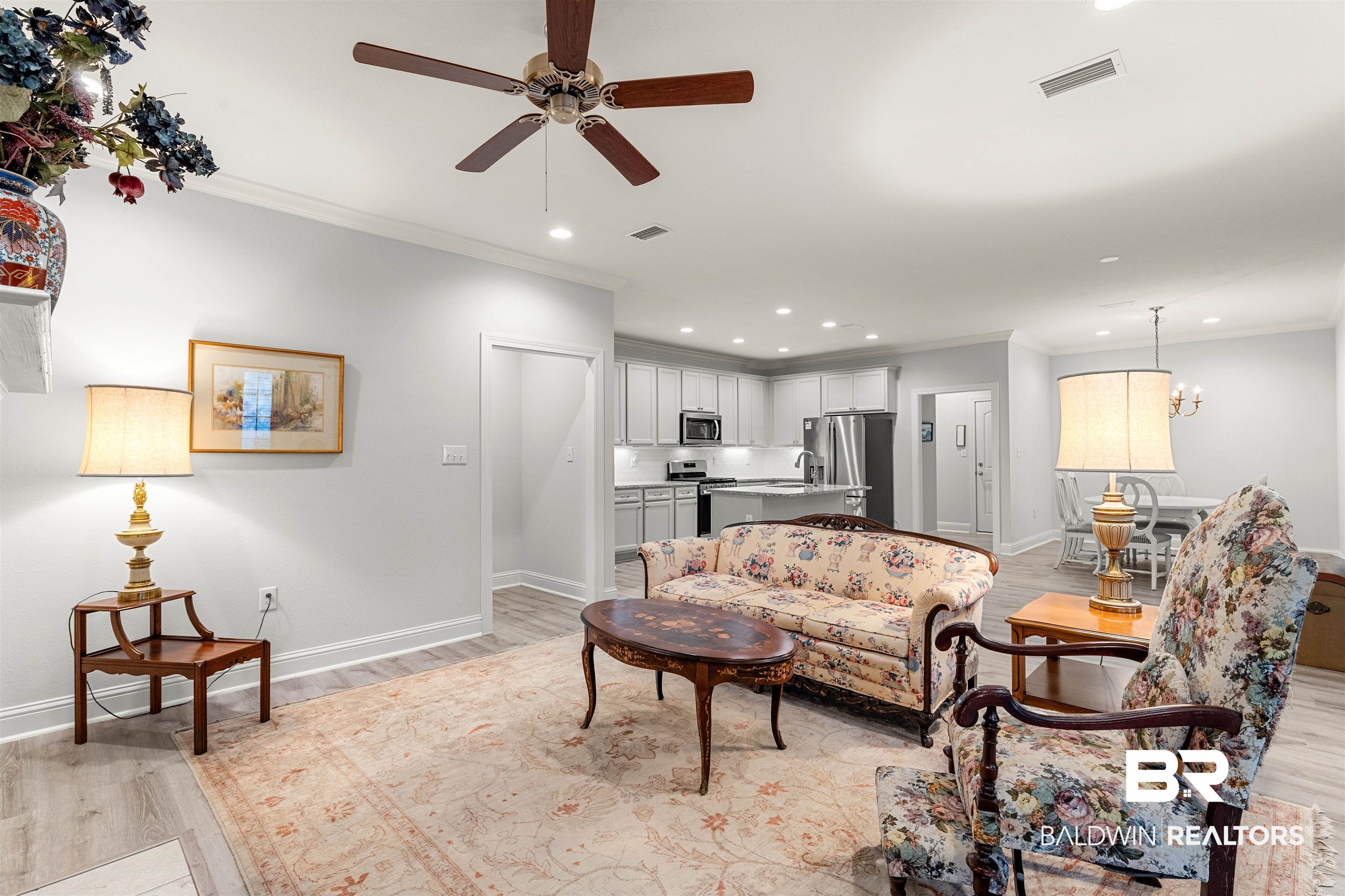 702 Holmes Avenue, Unit 702 Foley, AL 36535 - Photo 5 of 33 Living room featuring ornamental molding, light wood-type flooring, and ceiling fan with notable chandelier