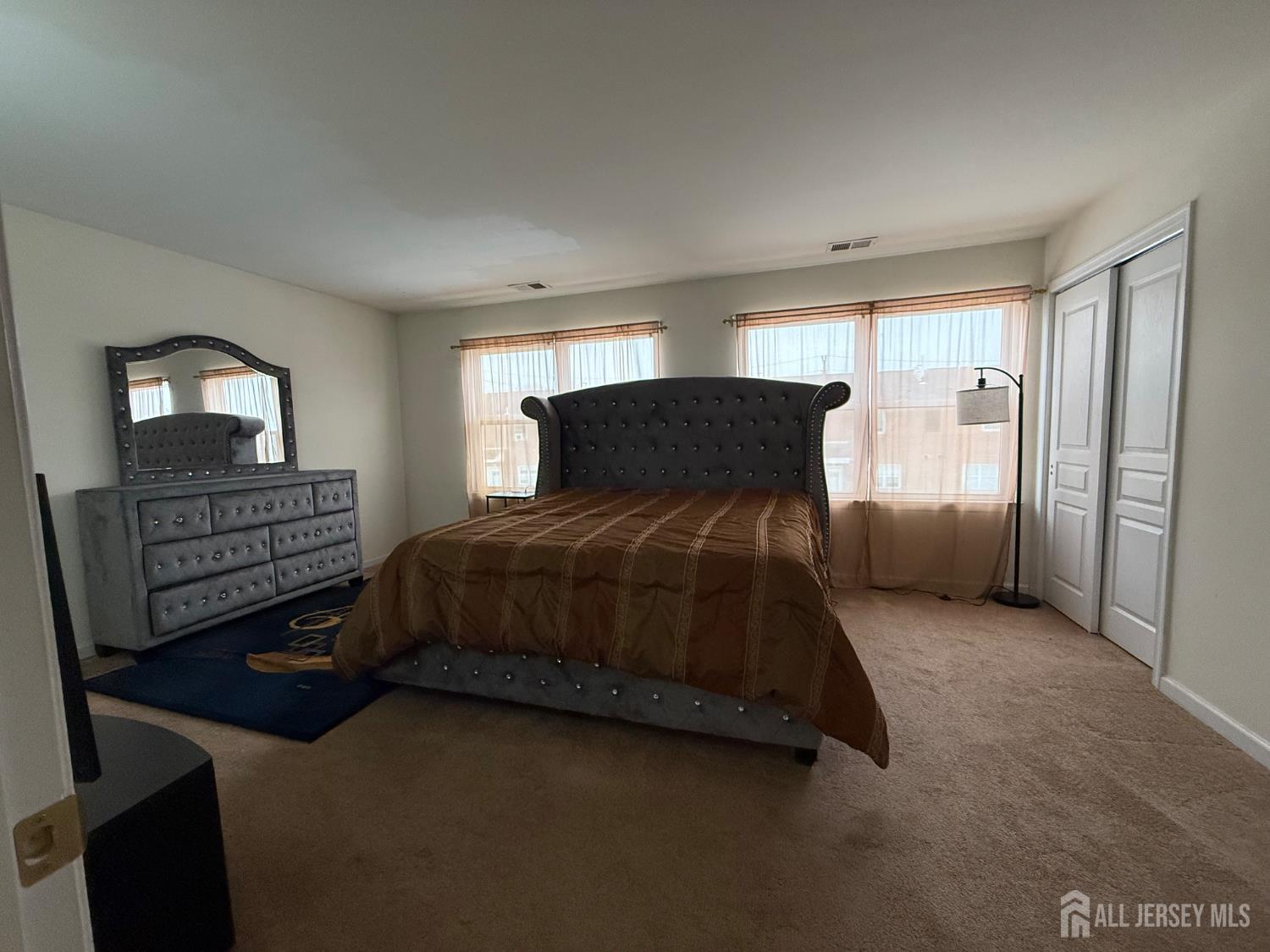34 Mercer Street Carteret, NJ 07008 - Photo 16 of 17 a bedroom with a bed and dresser with mirror