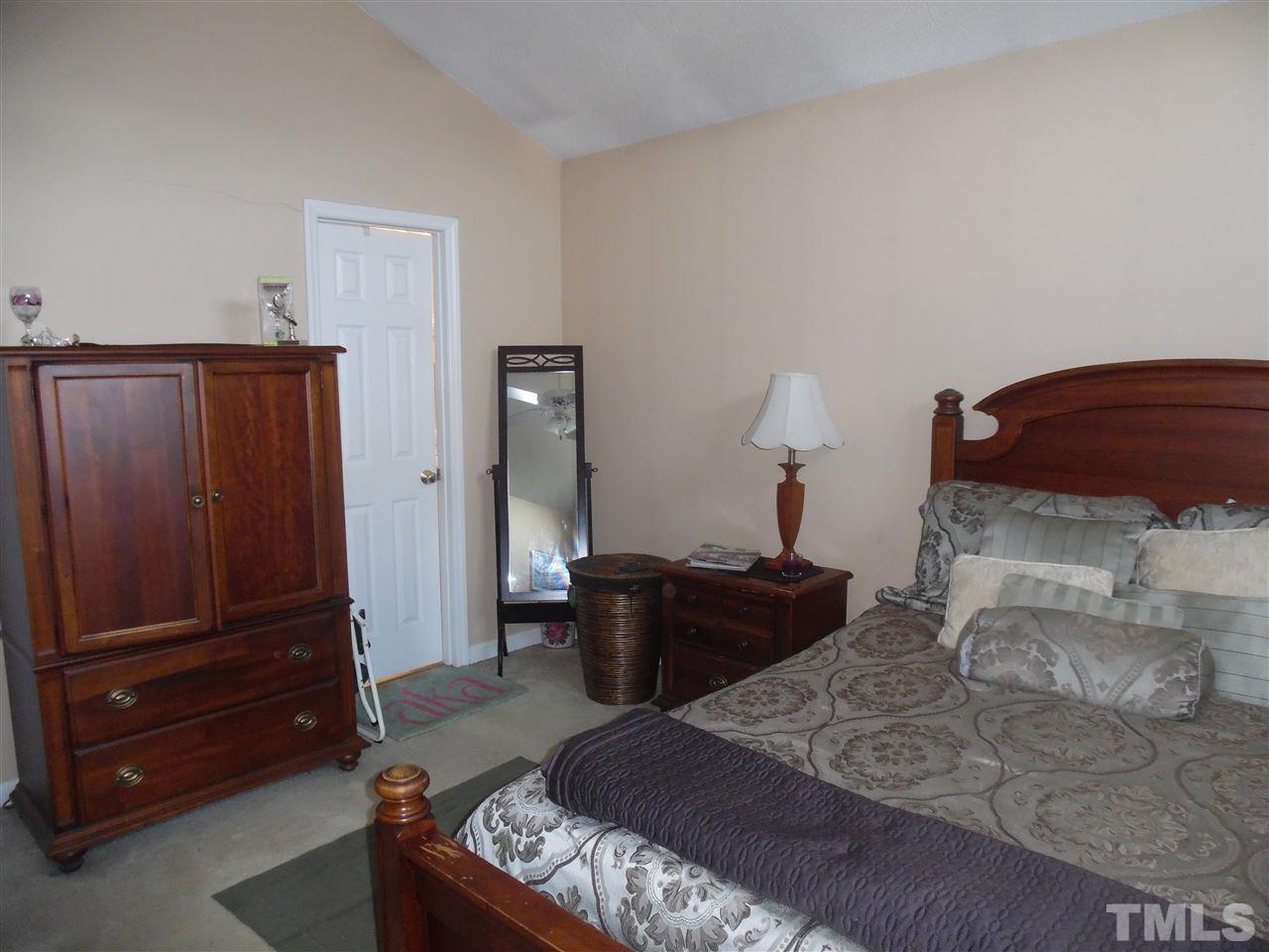 7104 Spanglers Spring Way Raleigh, NC 27610 - Photo 12 of 18 a bedroom with a bed and wooden floor