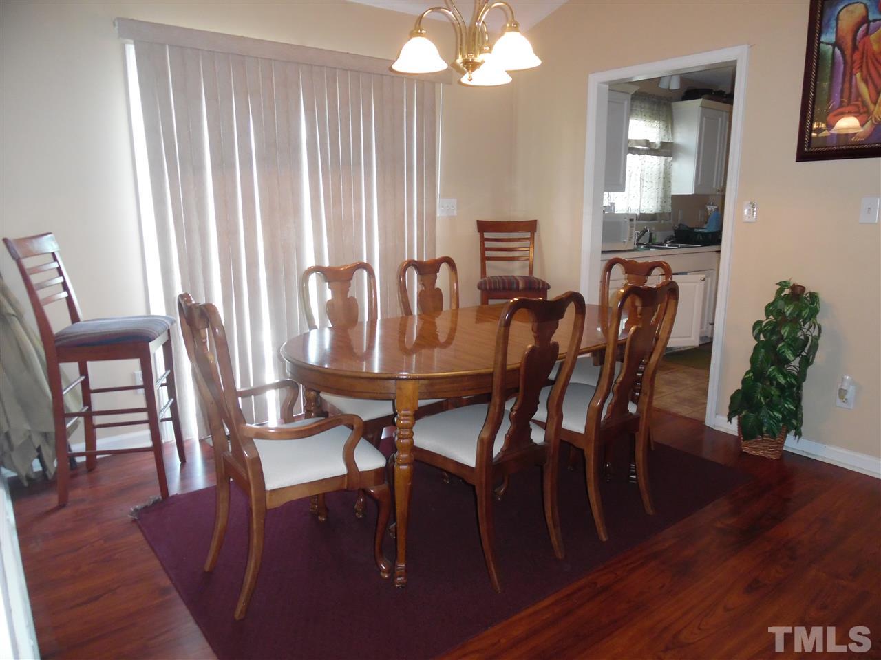 7104 Spanglers Spring Way Raleigh, NC 27610 - Photo 14 of 18 a view of a dining room with furniture and wooden floor