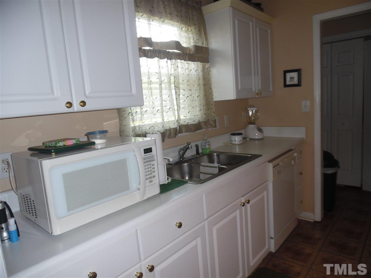7104 Spanglers Spring Way Raleigh, NC 27610 - Photo 17 of 18 a kitchen with white cabinets and window