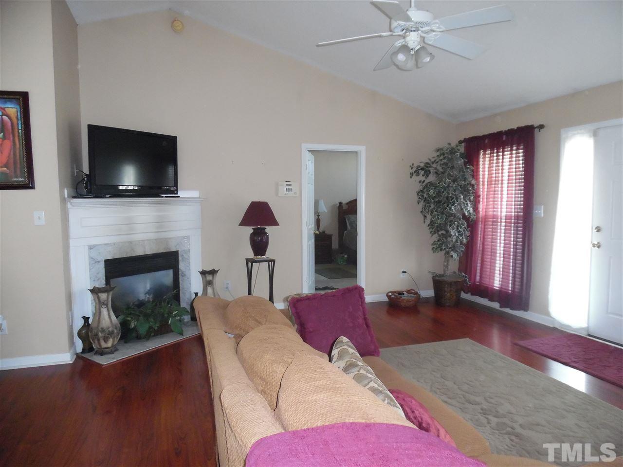 7104 Spanglers Spring Way Raleigh, NC 27610 - Photo 18 of 18 a living room with furniture a flat screen tv and a fireplace