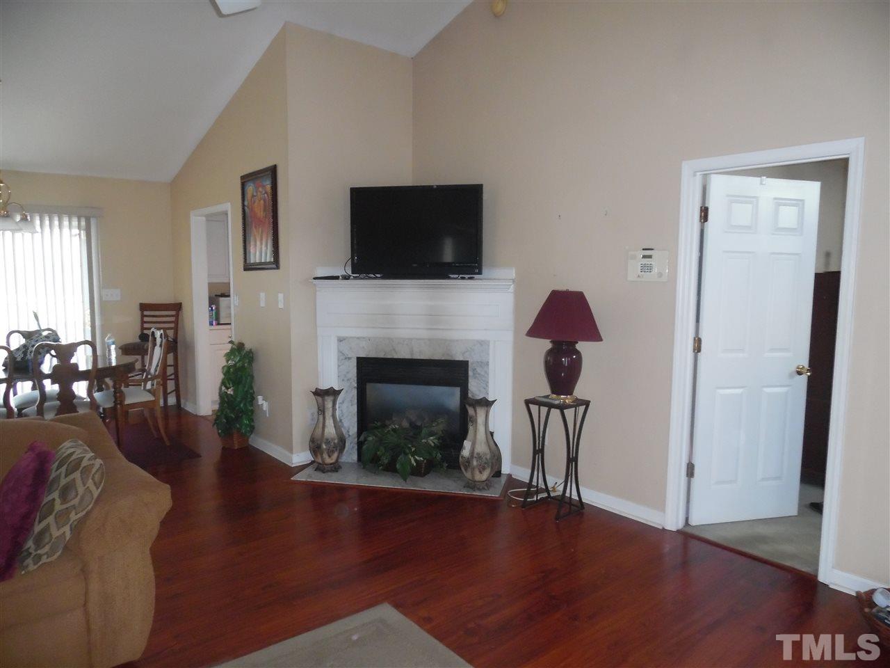 7104 Spanglers Spring Way Raleigh, NC 27610 - Photo 6 of 18 a living room with furniture a fireplace and a flat screen tv
