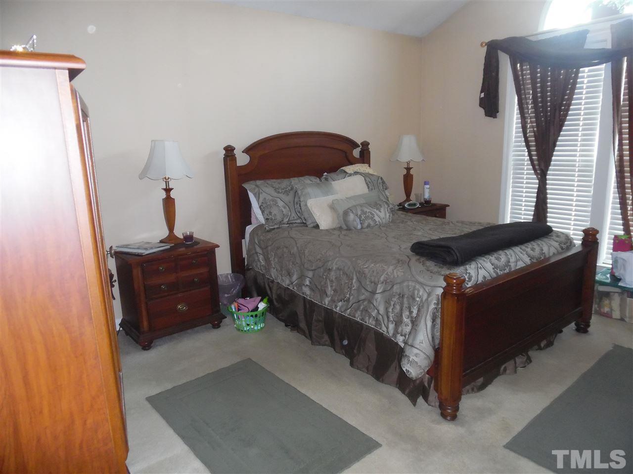 7104 Spanglers Spring Way Raleigh, NC 27610 - Photo 9 of 18 a bedroom with a bed and a dresser in it