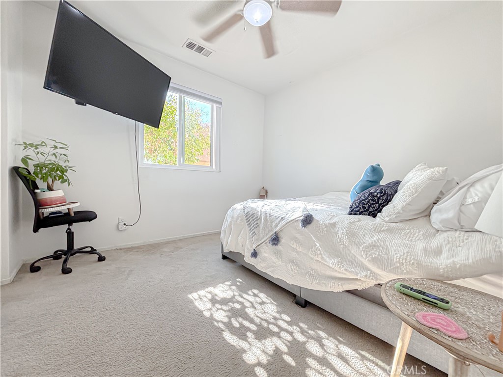 3345 James Court Lancaster, CA 93535 - Photo 20 of 29 a bedroom with a bed a flat screen tv and a chandelier