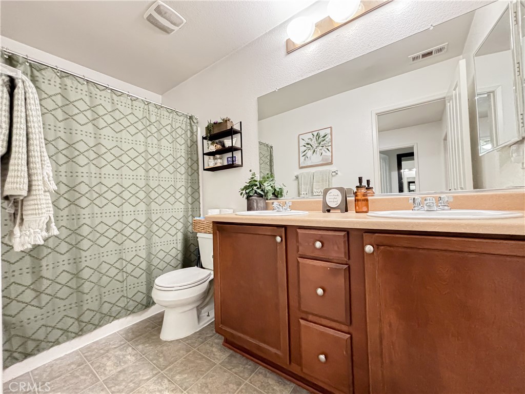 3345 James Court Lancaster, CA 93535 - Photo 24 of 29 a bathroom with a double vanity sink toilet and a mirror