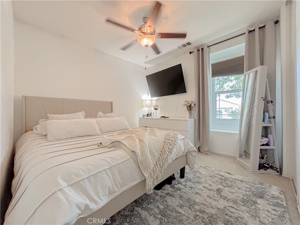 3345 James Court Lancaster, CA 93535 - Photo 25 of 29 a bedroom with a bed a flat screen tv and a ceiling fan