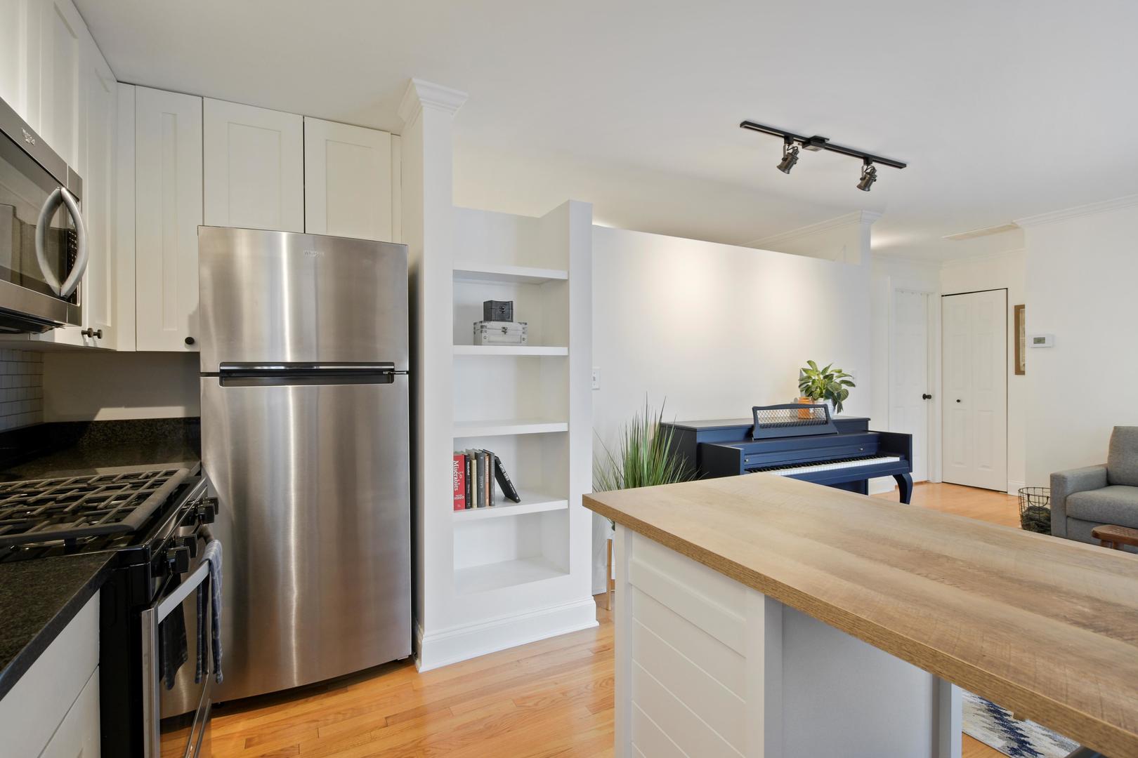 4144 North Sheridan Road, Unit 209 Chicago, IL 60613 - Photo 9 of 17 a kitchen with kitchen island a counter appliances a sink and cabinets