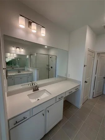 a spacious bathroom with a double vanity sink a mirror and a shower
