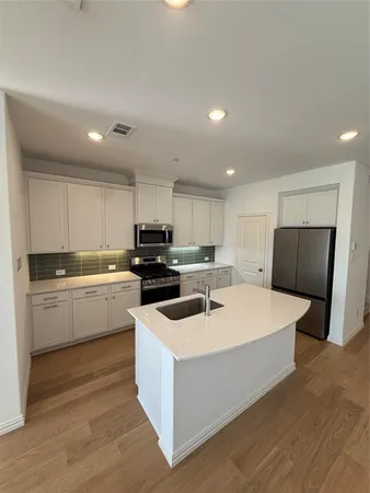 a kitchen with kitchen island sink stove and refrigerator