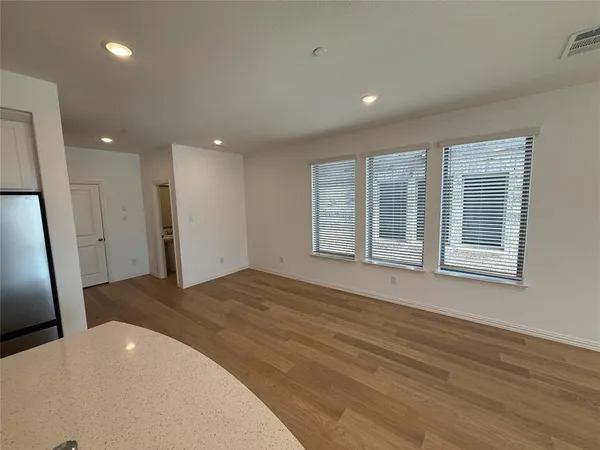 a view of a kitchen with a sink and dishwasher a refrigerator with wooden floor