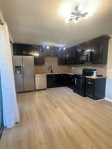 a large kitchen with stainless steel appliances granite countertop a sink and a stove