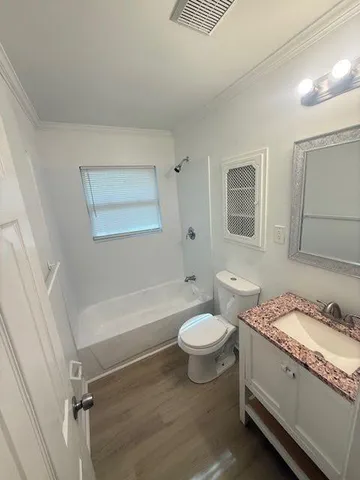 a bathroom with a granite countertop sink mirror vanity and a bathtub