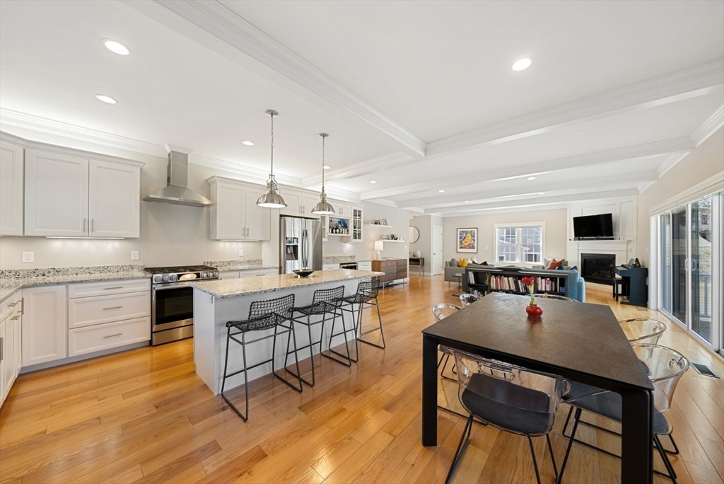 7 Hayes Road Hingham, MA 02043 - Photo 5 of 34 a open dining room with stainless steel appliances kitchen island granite countertop a stove a sink a dining table and chairs with wooden floor