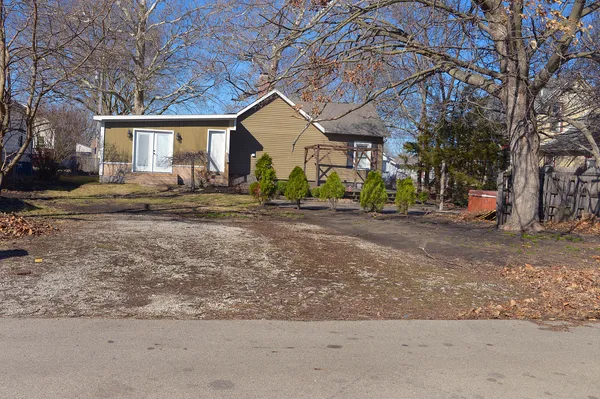 a view of a house with large space and a car parked beside it