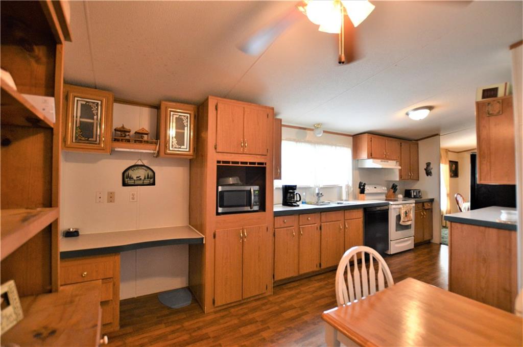 4015 Beach Road Hudson, NC 28638 - Photo 7 of 22 a kitchen with stainless steel appliances granite countertop a stove top oven a sink a dining table and chairs with wooden floor
